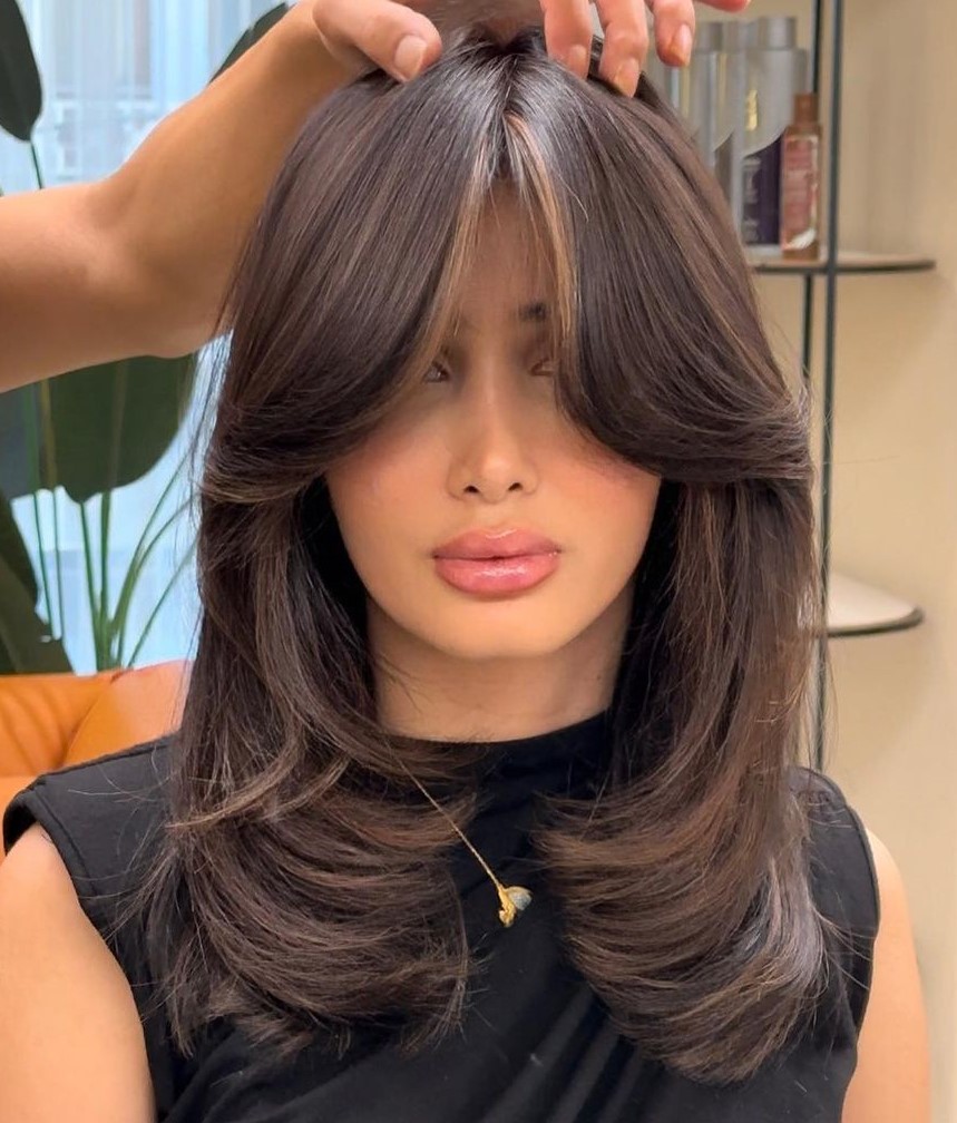 Collarbone-Skimming Hair with Layers and Curtain Bangs Thick Layered Hair with Cheekbone Length Curtain Bangs