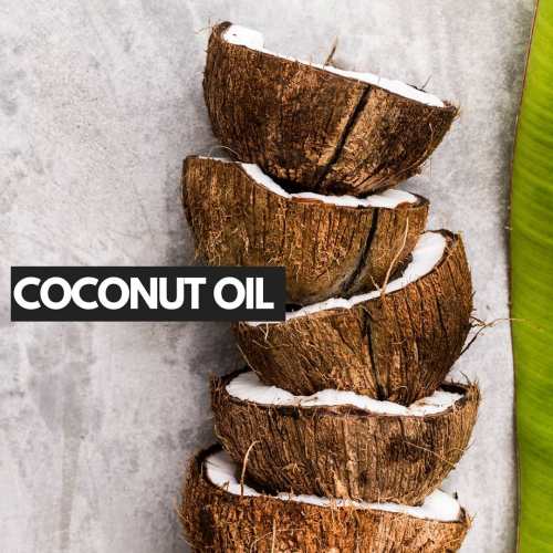 Coconut Oil Against Piled Coconuts